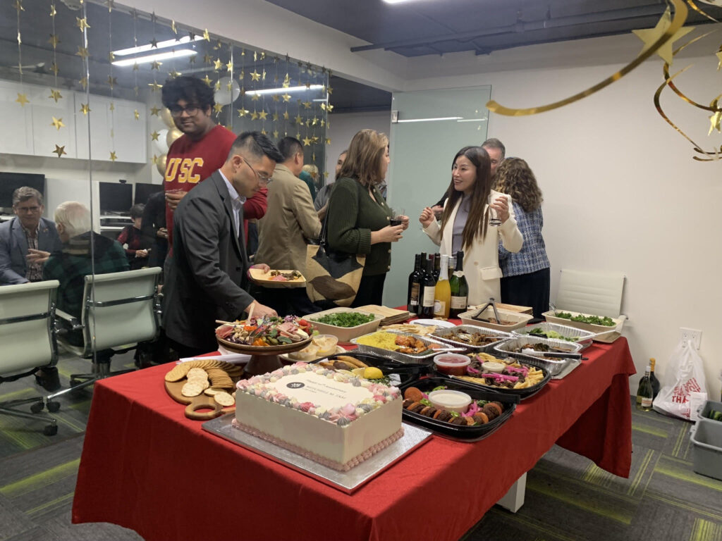 Firm guests gathered around the spread of food. 